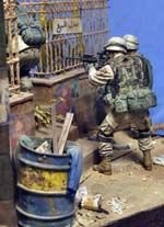 Magnífica viñeta/diorama ambientada en Irak de un grupo de soldados peinando una calle casa por casa en busca de terroristas o insurgentes. 